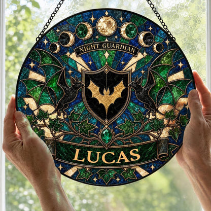 Round stained-glass suncatcher with gold bat shield, two black bats, moon phases, emerald gem, ivy and starbursts.