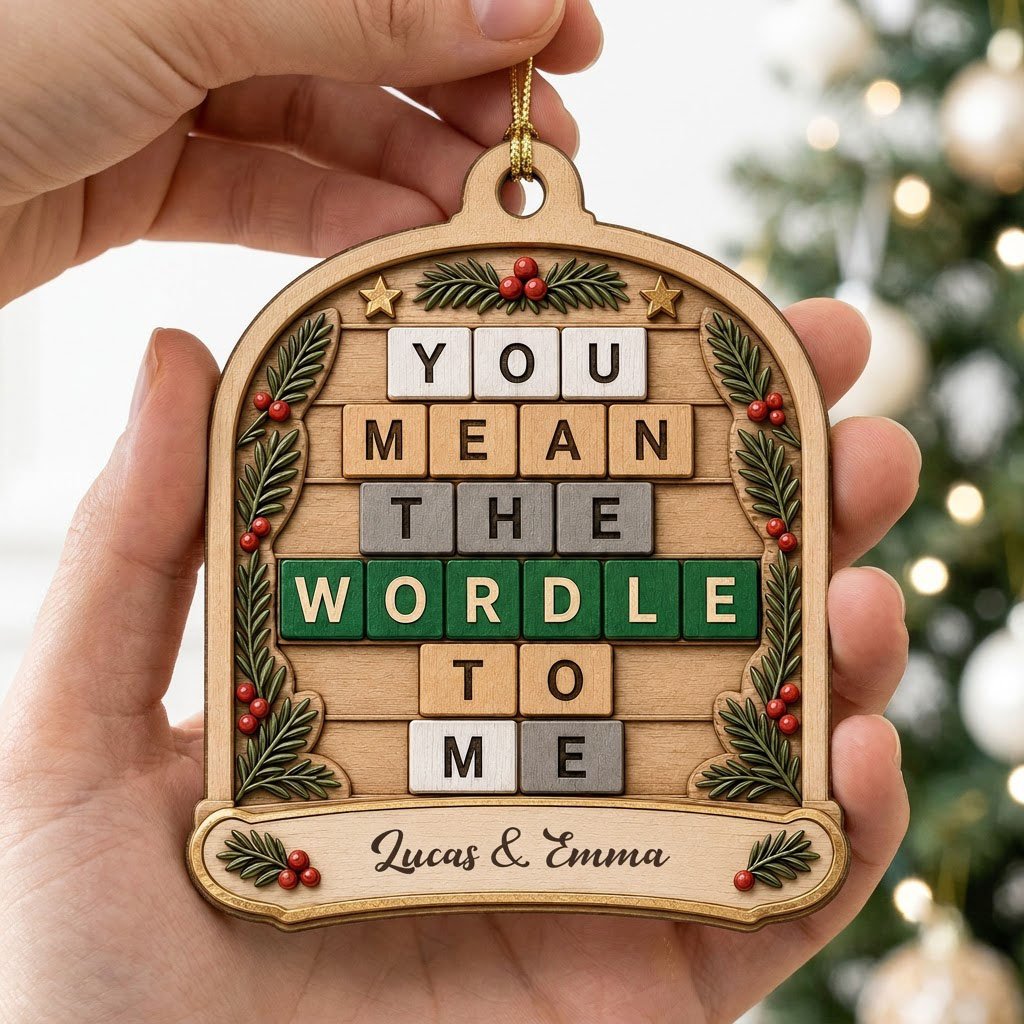 Arch wood ornament with “You Mean The Wordle To Me” letter tiles, evergreen sprigs with red berries, gold stars, and cou