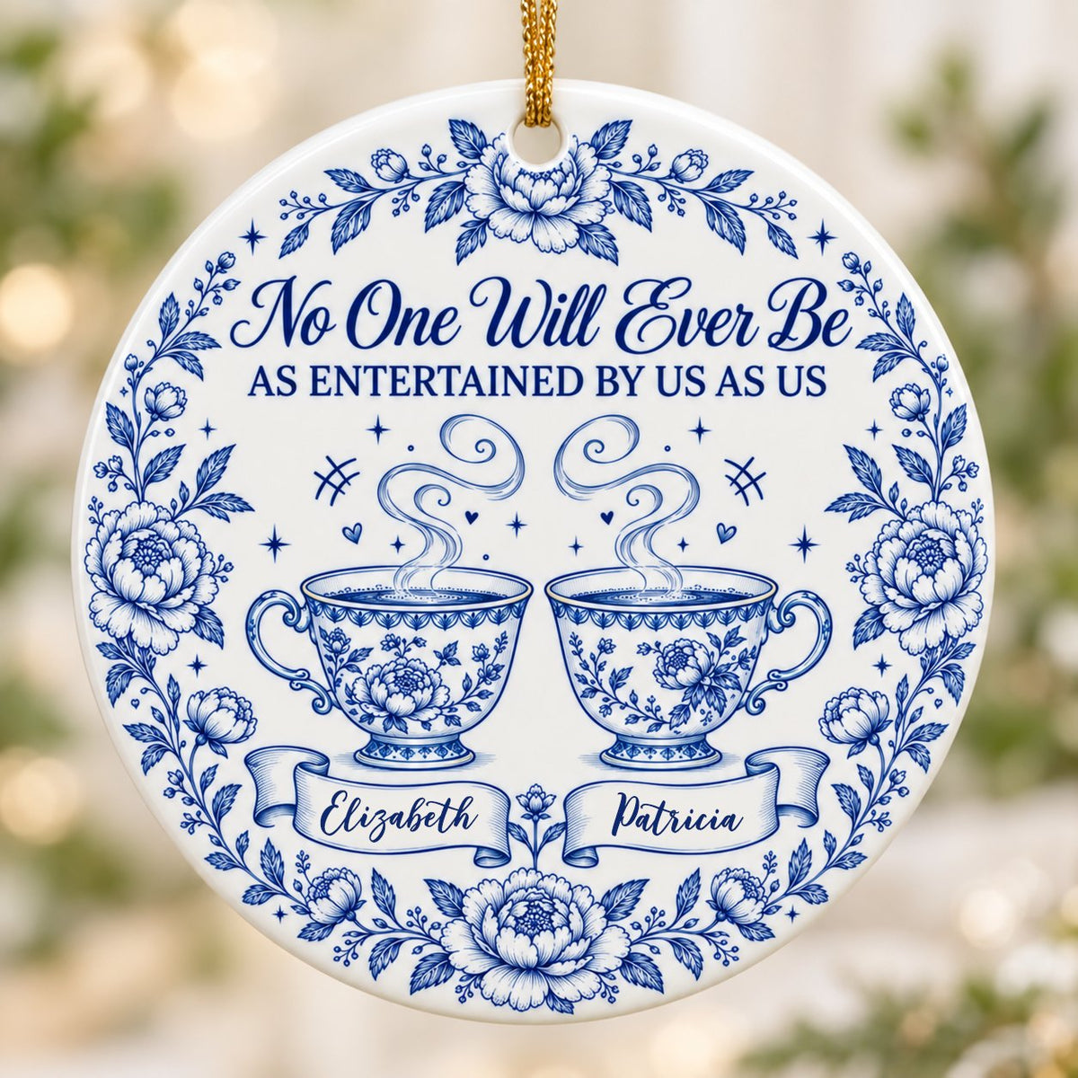 Round white ceramic ornament with blue floral border and two teacups, personalized with two names