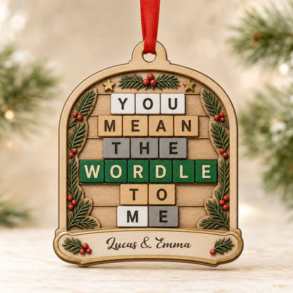 Arch wood ornament with “You Mean The Wordle To Me” letter tiles, evergreen sprigs with red berries, gold stars, and cou