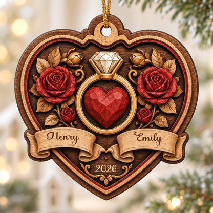 Heart-shaped wood ornament with a gold ring, red heart, red roses, and names Henry and Emily with year 2026.