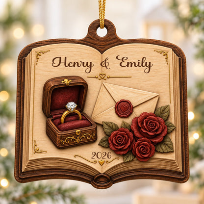 Open book wood ornament with a ring box, red roses, wax-sealed envelope, and custom names and year.