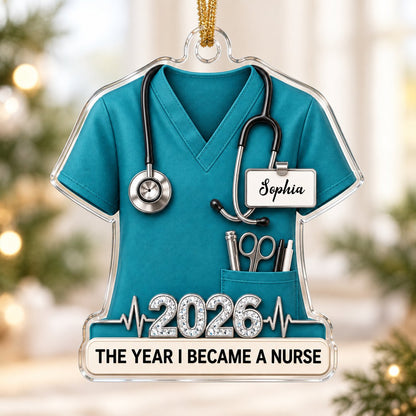 Teal scrub top acrylic ornament with stethoscope, ID badge, pocket tools, EKG line, 2026 numerals and a white name banne
