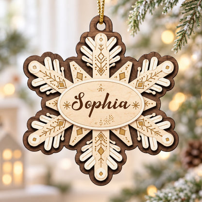 Layered wood snowflake ornament with geometric engravings and a central oval name plate for a custom name.