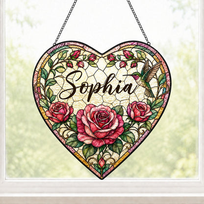Heart stained-glass suncatcher with pink and red roses, a right-side hummingbird, and a multi-colored border.