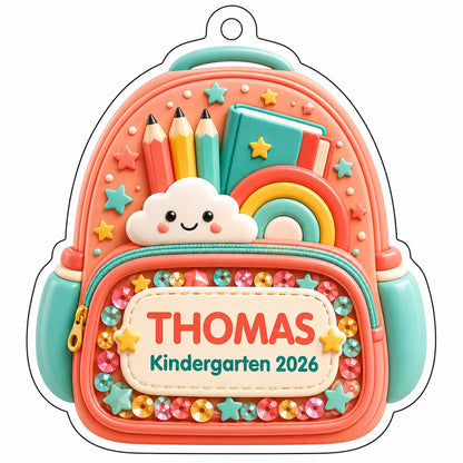 Coral backpack acrylic ornament with pencils, rainbow, smiling cloud, and 'THOMAS' Kindergarten 2026.