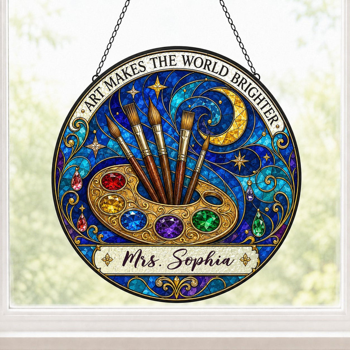 Round stained-glass suncatcher with golden palette, five brushes, moon, and 'Art Makes the World Brighter'.