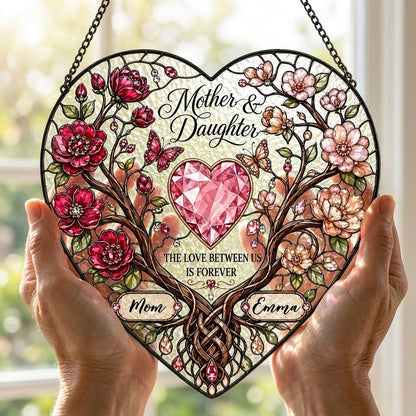 Heart-shaped stained-glass style suncatcher with intertwined trees, red and pink flowers, butterflies, and a pink gem he