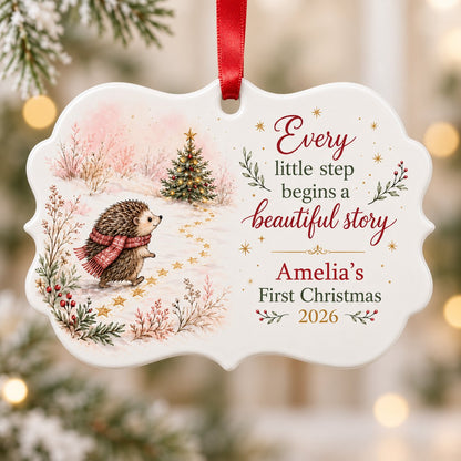 Scalloped ceramic ornament with hedgehog in red plaid scarf walking toward a decorated Christmas tree in the snow.