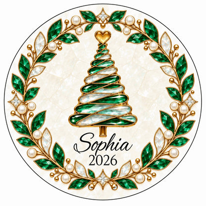 Round ceramic ornament with an emerald jeweled spiral Christmas tree and gold filigree wreath on cream.