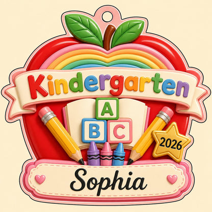 Red apple acrylic ornament with 'Kindergarten 2026', rainbow, ABC blocks, crayons, pencils, star badge, and a name banne