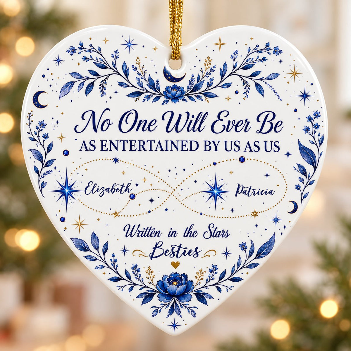 White heart ceramic ornament with blue florals, moons, stars, and “Written in the Stars Besties” with two names.
