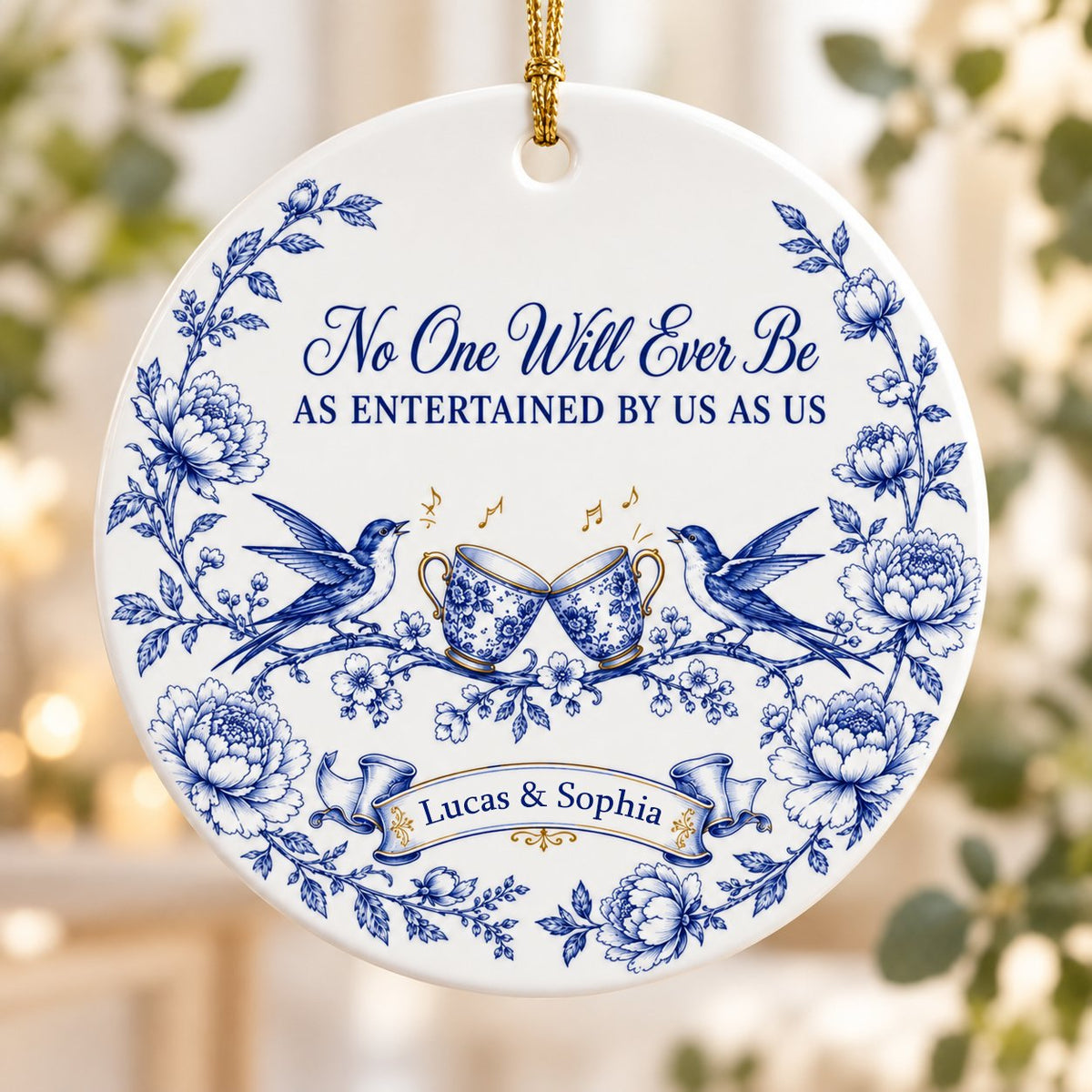 Round ceramic ornament with blue toile border, two birds, clinking floral teacups and gold music notes with two names.