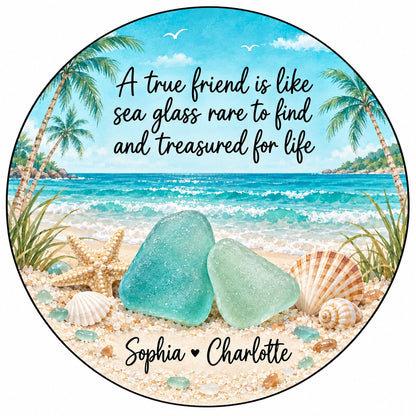 Round ceramic ornament with beach scene, palm trees, sea glass, shells, and a friendship quote with two names.