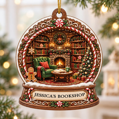 Snow globe ornament with candy-cane frame, cozy book-filled library, fireplace, tree, and 'JESSICA'S BOOKSHOP' nameplate
