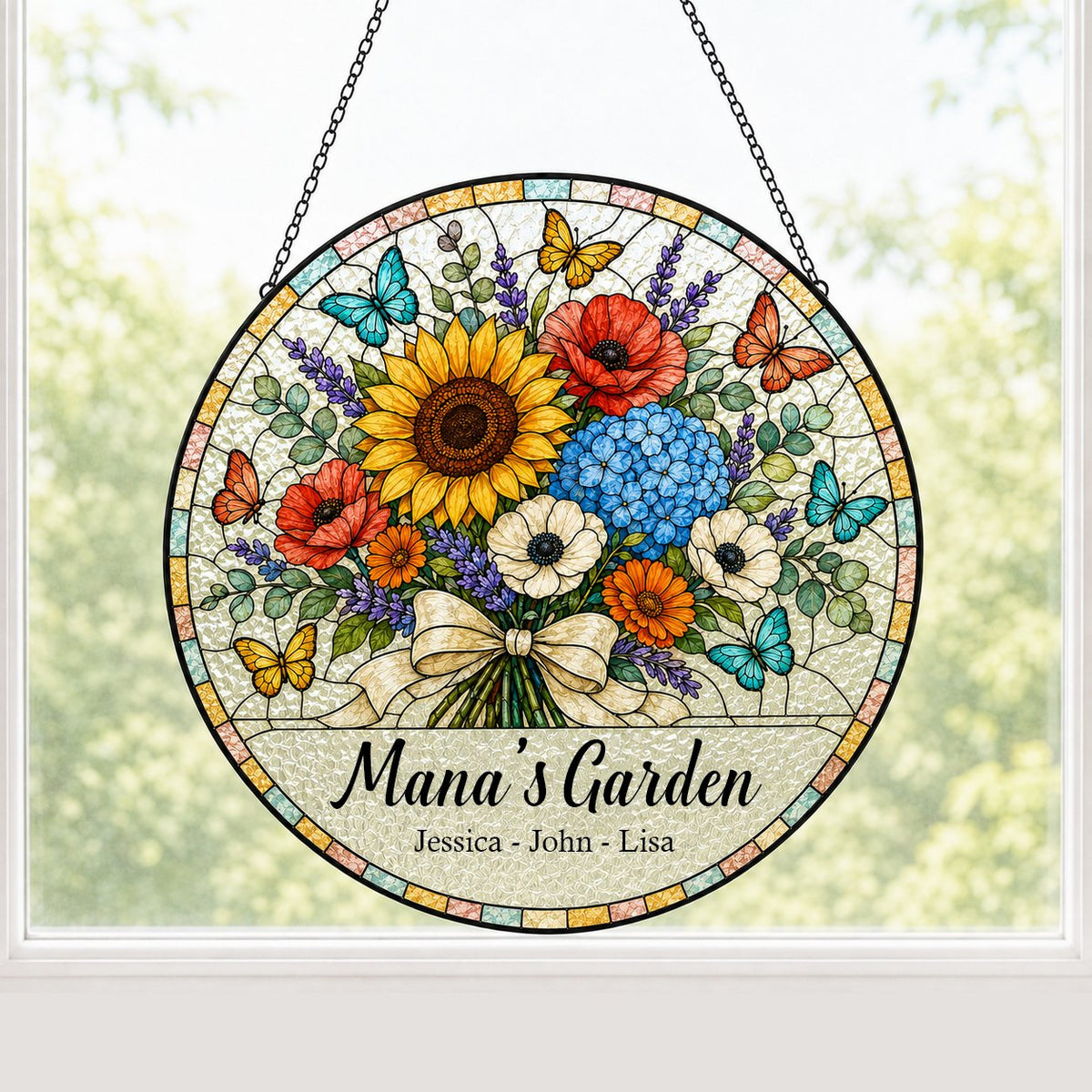 Round stained-glass style suncatcher with floral bouquet, butterflies, and 'Mana's Garden' with names.