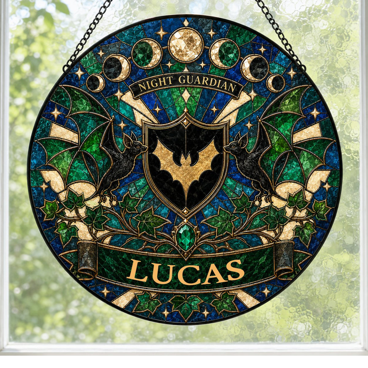 Round stained-glass suncatcher with gold bat shield, two black bats, moon phases, emerald gem, ivy and starbursts.