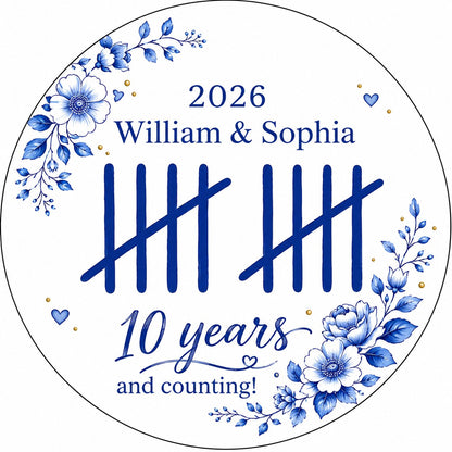 White round ceramic ornament with blue florals, tally marks, and 'years and counting!' plus names and year