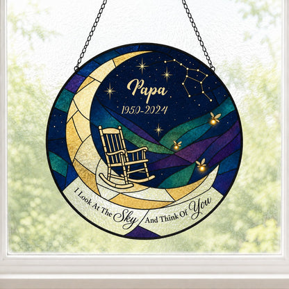 Round stained-glass suncatcher with a crescent moon, rocking chair, fireflies and a memorial banner.