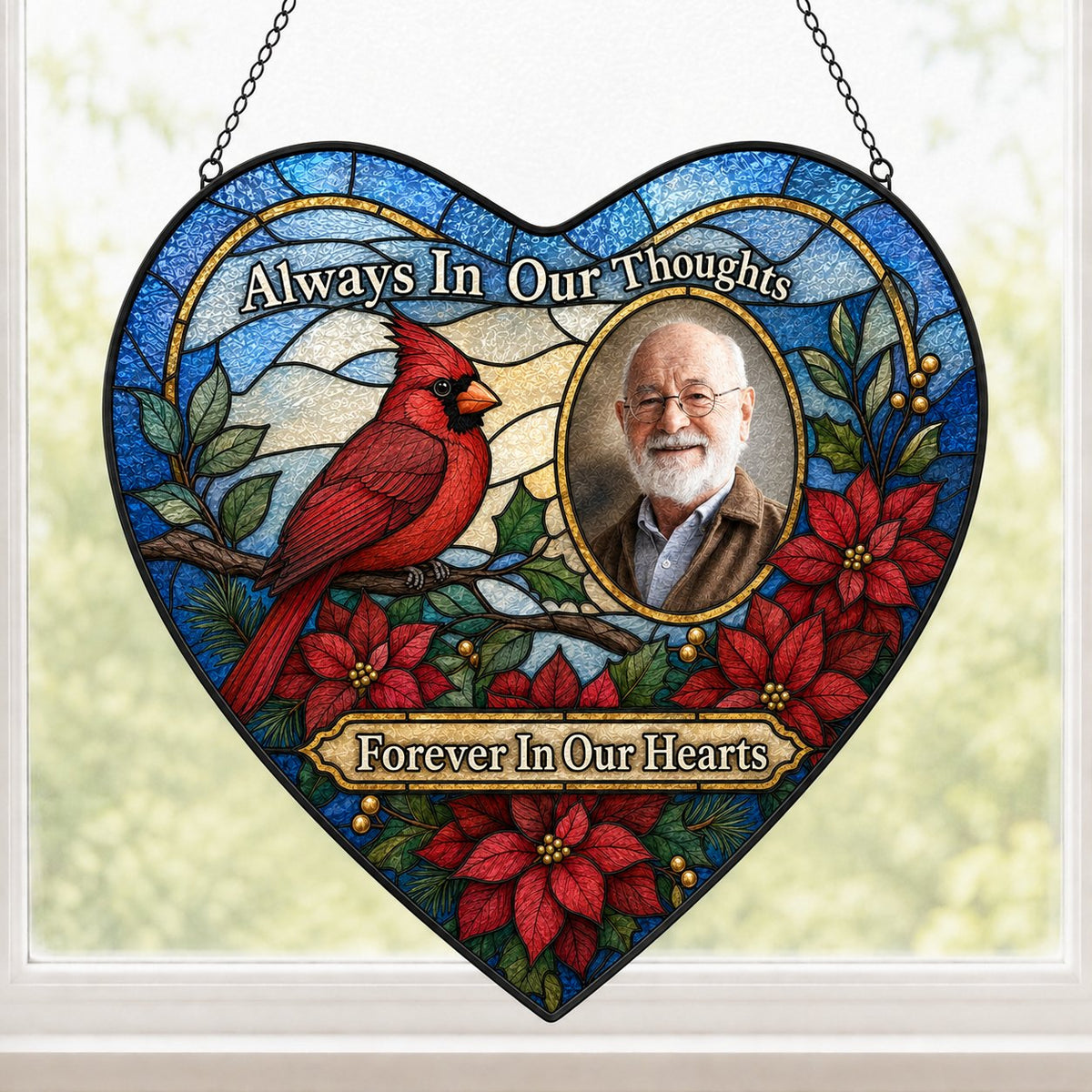 Heart stained glass suncatcher with red cardinal, oval memorial photo frame, and red poinsettias with green leaves.