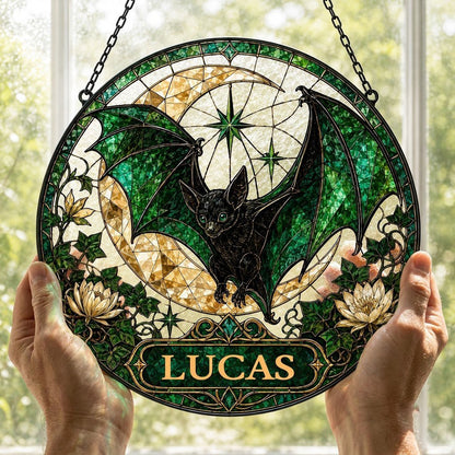 Round stained-glass style suncatcher with black bat, green wings, crescent moon, ivy, white flowers, and a personalized 