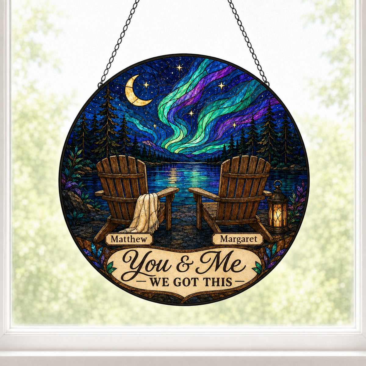 Round stained-glass style suncatcher with aurora, crescent moon, pine trees, lake, two chairs and a lantern.